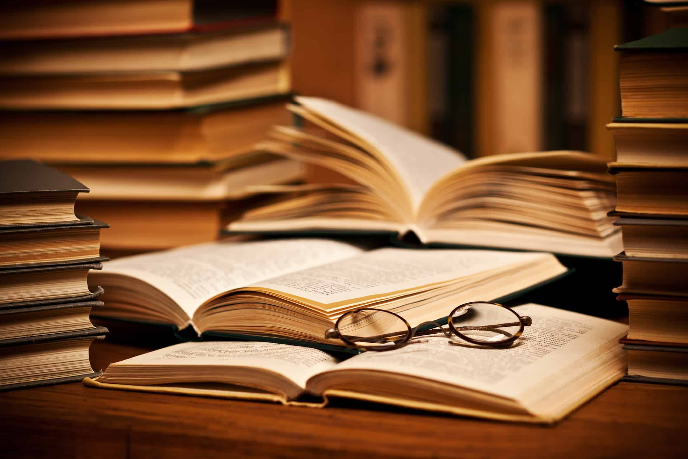 opened book, lying on the bookshelf with a glasses